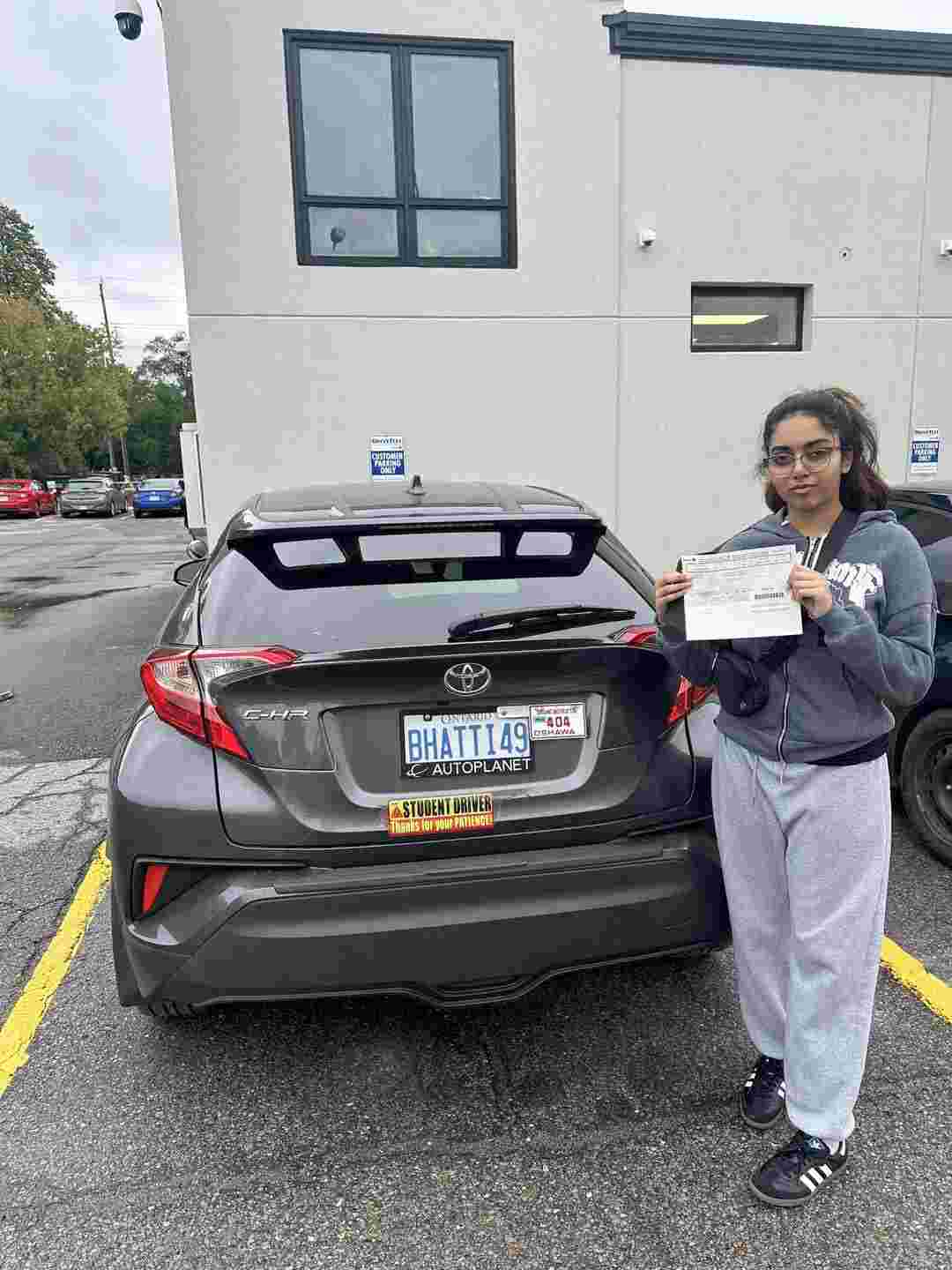 a girl holding a driving licence after completing training from drive vision school